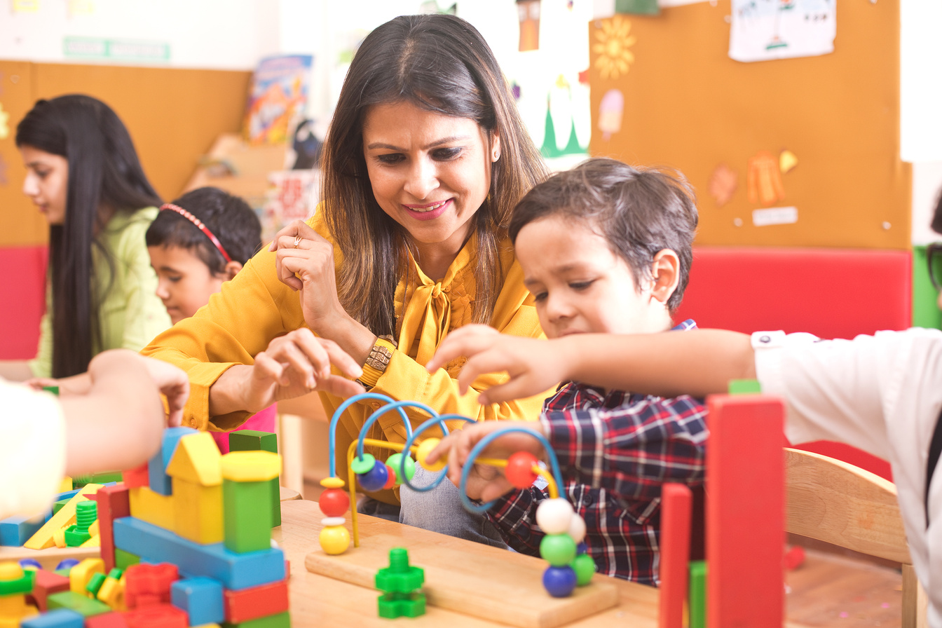 Teachers with children learning at preschool